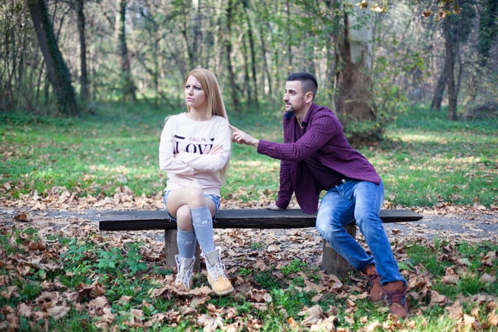 Young couple in autumn park. Woman angry about her boyfriend.