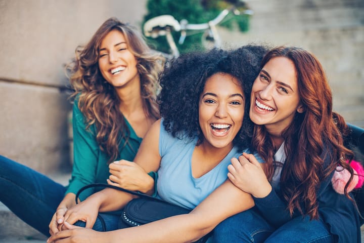 Small multi-ethnic group of beautiful young women laughing outdoors