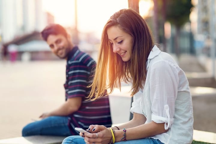 Man flirting with a girl sitting on a close bench