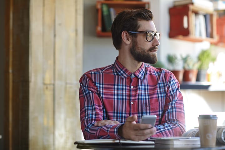 Guy daydreaming with smart phone
