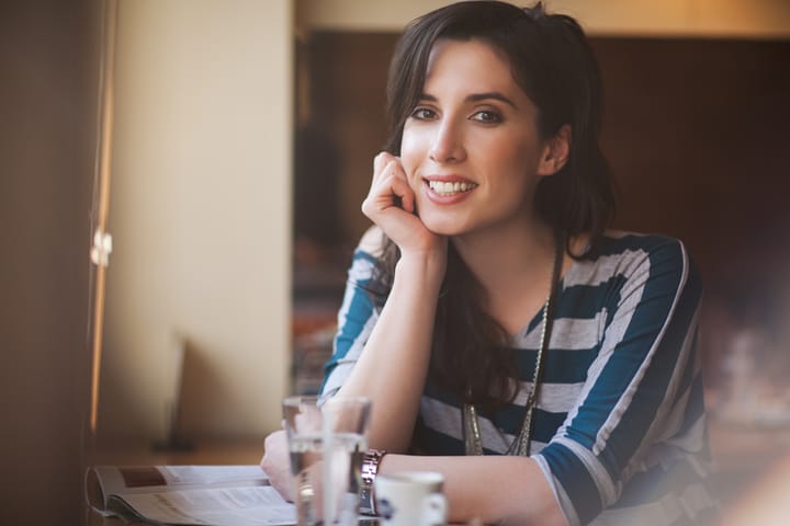 Smiling Caucasian woman sitting at a cafe.