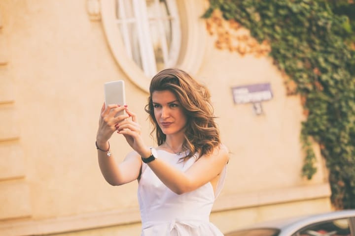 Young beautiful fashionable woman using cellphone outdoors.