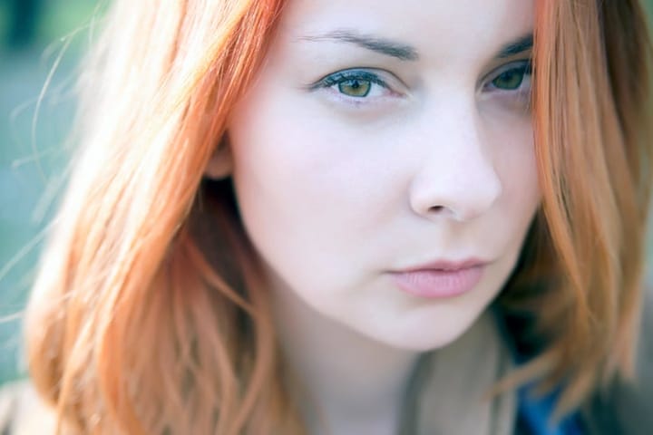Portrait of red-haired beautiful young woman outside
