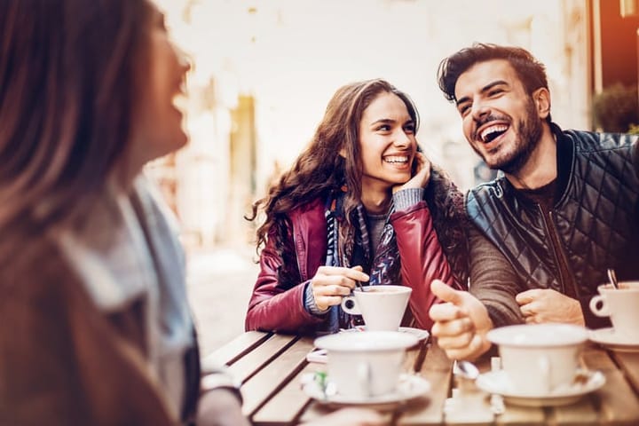 Group of cheerful people having coffee and tea in a bistro
