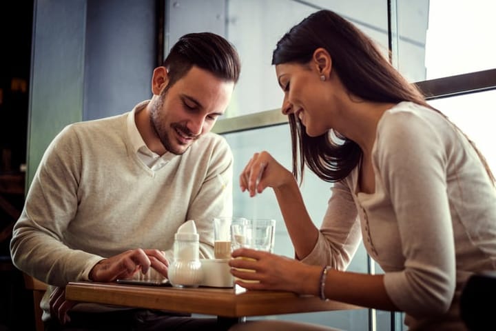Shot of a young couple sitting with a tablet while on a coffee date.Couple drinking coffee and chatting in cafe.