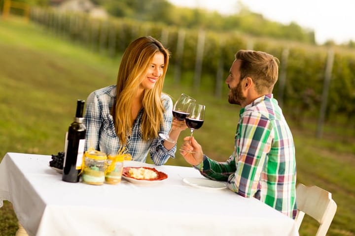 Young couple having dinner at vineyard countryside
