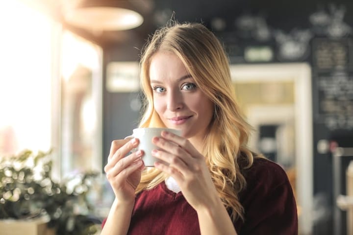 Young woman is drinking a cup of coffee