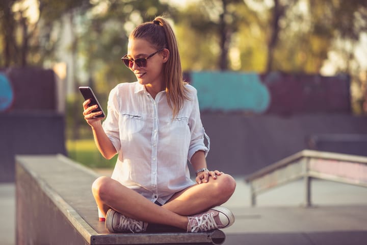 Trending woman sitting on a wall mobile