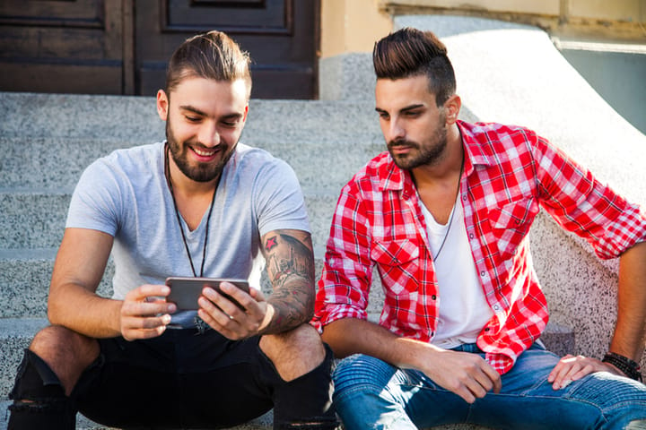 Group of young hipster friends having fun together with smartphone
