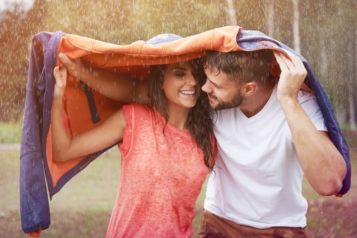 couple under coat in rain
