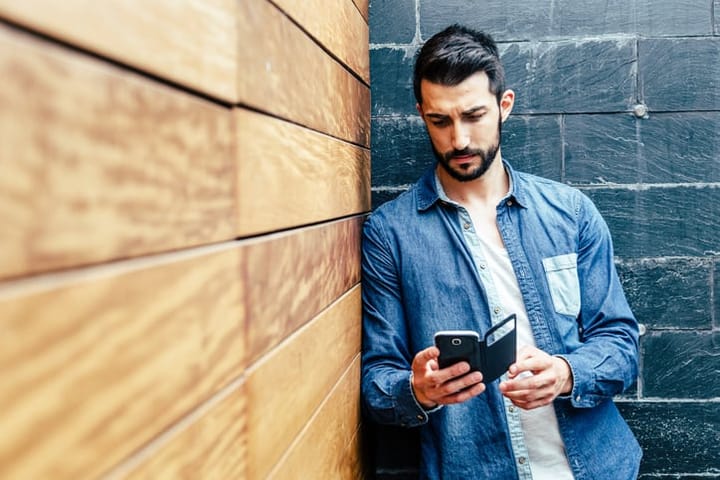 Attractive bearded young man with his smartphone