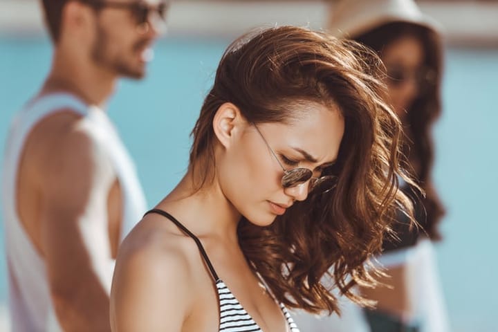 Beautiful pensive young woman in sunglasses