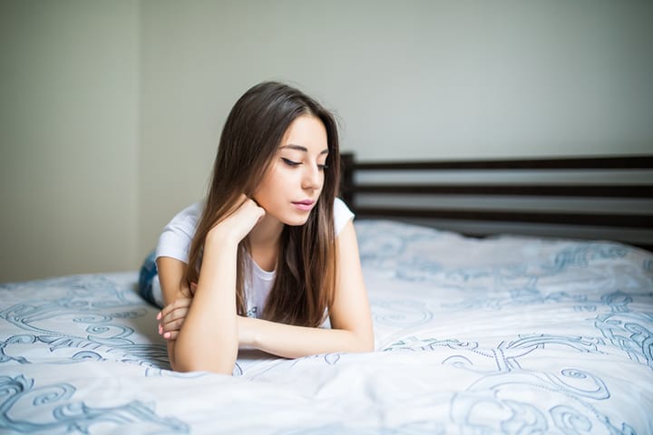 Portrait of a beautiful young woman lying on bed