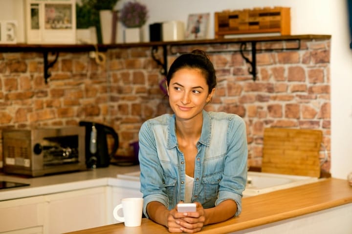 Beautiful woman relaxing at home with coffee and smartphone