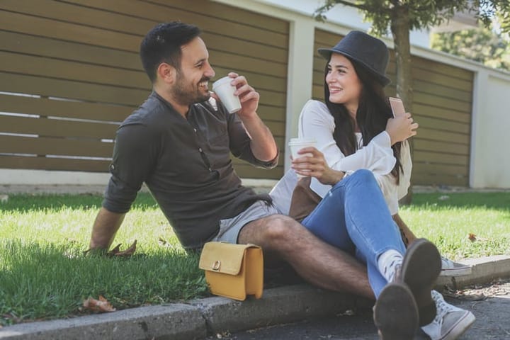 smiling couple having coffee at park