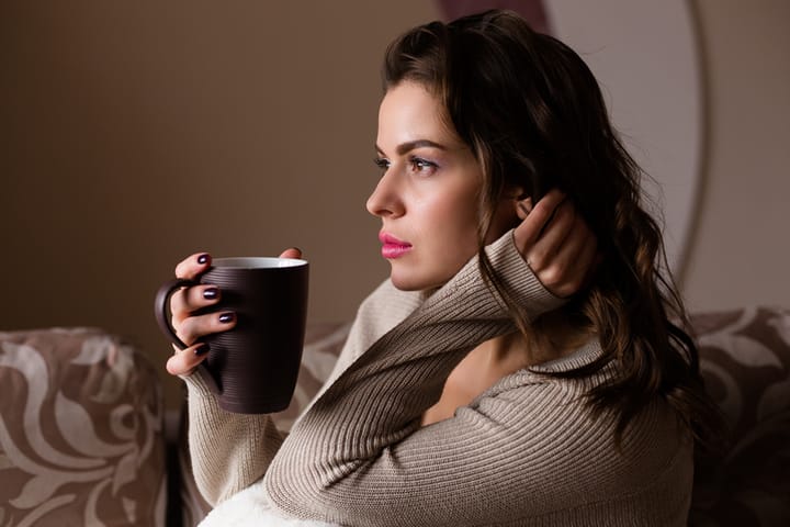 Young beautiful woman enjoying a cup of coffee at home