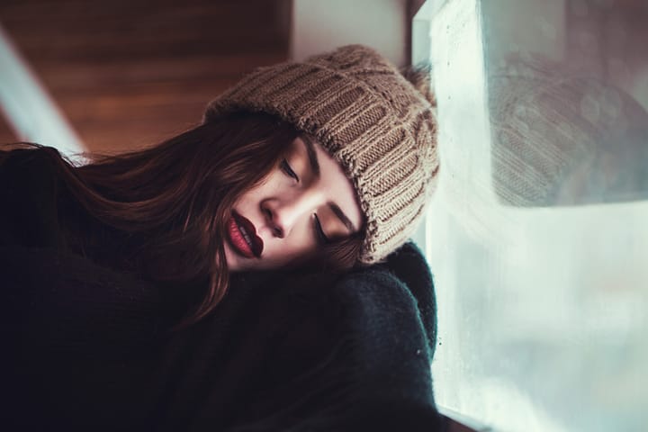 young woman sleeping infront of window
