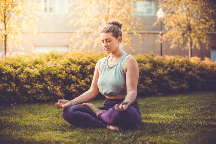 Woman outside doing yoga.