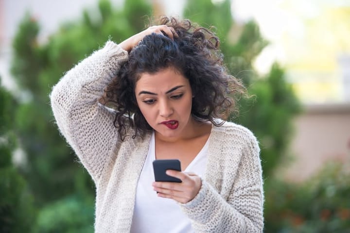 stressed woman staring at her phone