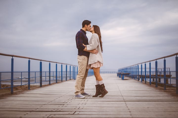 Romatic couple passionately kissing on dock