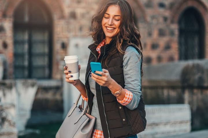 woman wearing gilet holding mobile