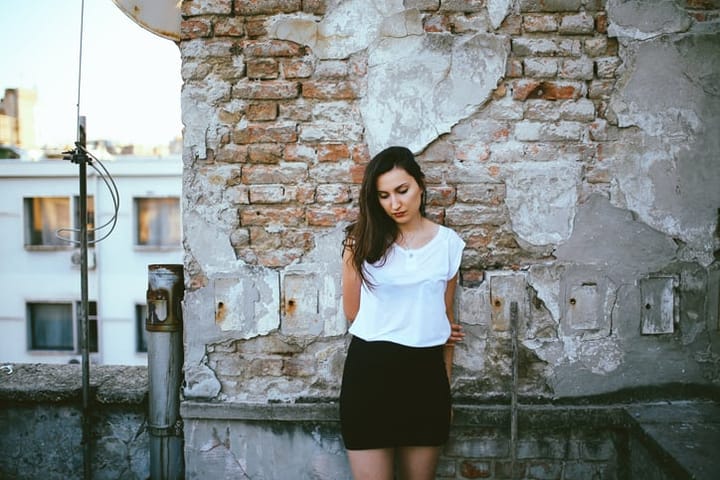young woman beside a wall