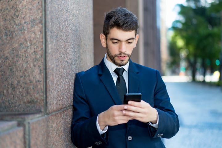 bearded man holding smart phone