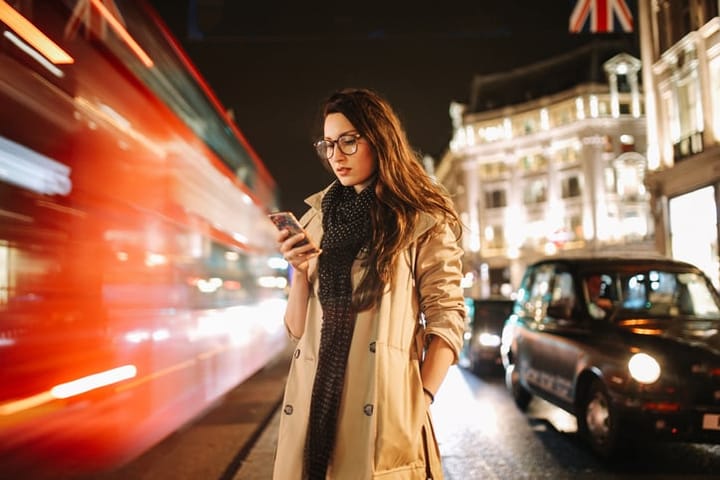 woman texting at night in london