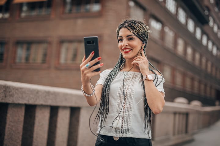 woman with braided hair smiling into phone