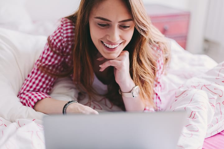 woman smiling looking at her laptop