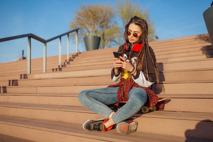 woman texting outside on steps
