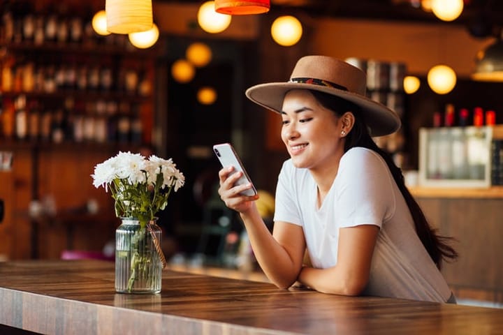 woman smiling looking at her smart phone