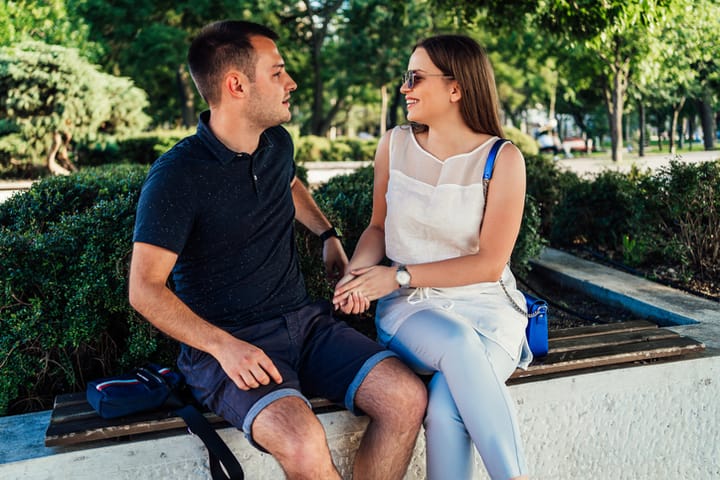 Young cheerful couple enjoying in conversation outdoor