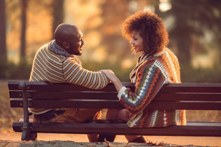 african american couple sitting on a bench