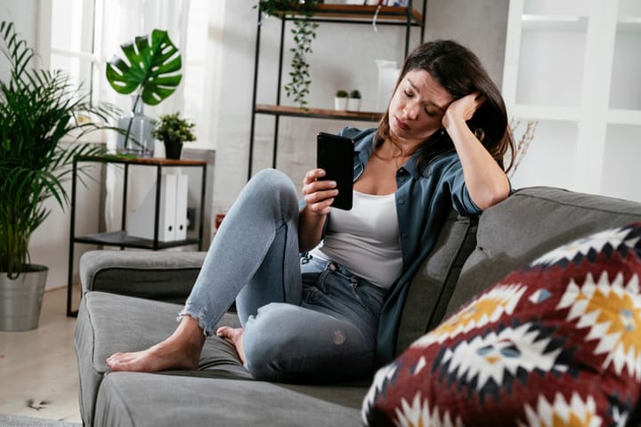 woman texting sitting on the sofa