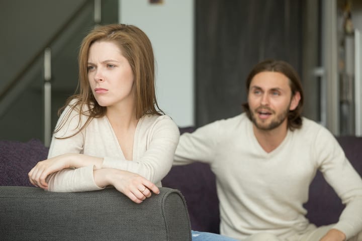 Unhappy young couple arguing, offended affronted woman ignoring angry man sitting her back to jealous husband shouting at frustrated wife, family fight at home, bad marriage relationships concept