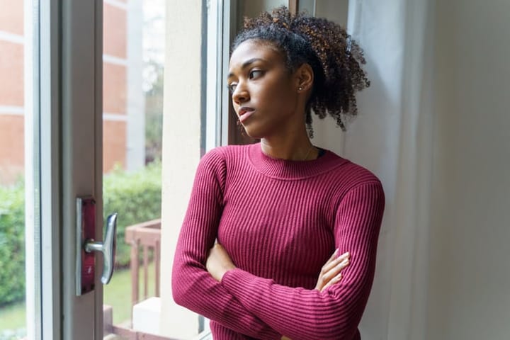 black woman looking out of a window