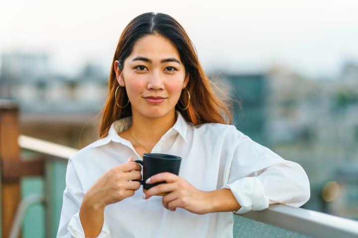 asian woman holding coffee cup
