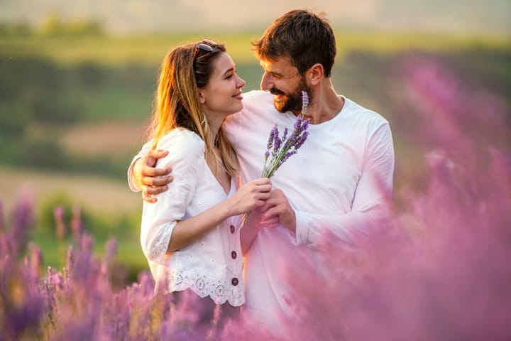 couple cuddling in purple field