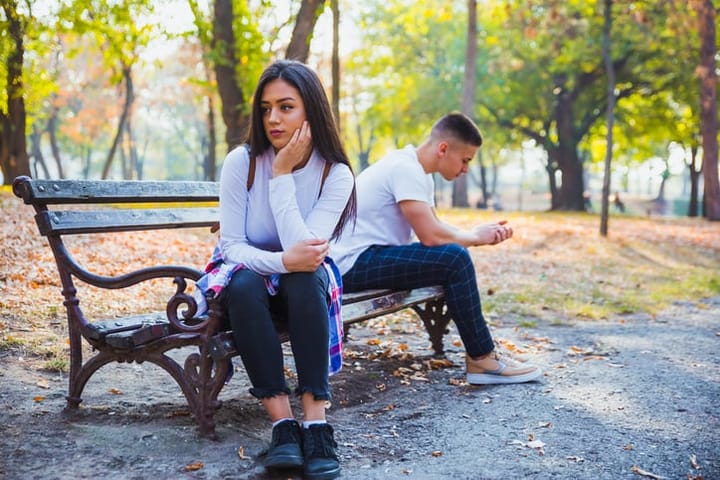 couple arguing outside bench