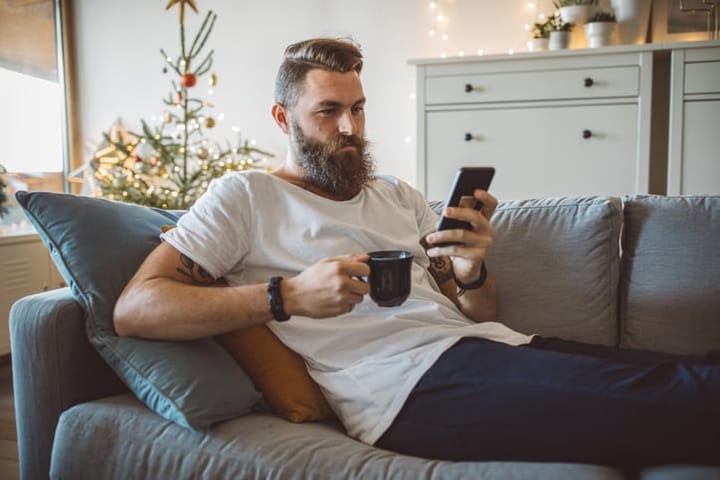bored guy texting on couch