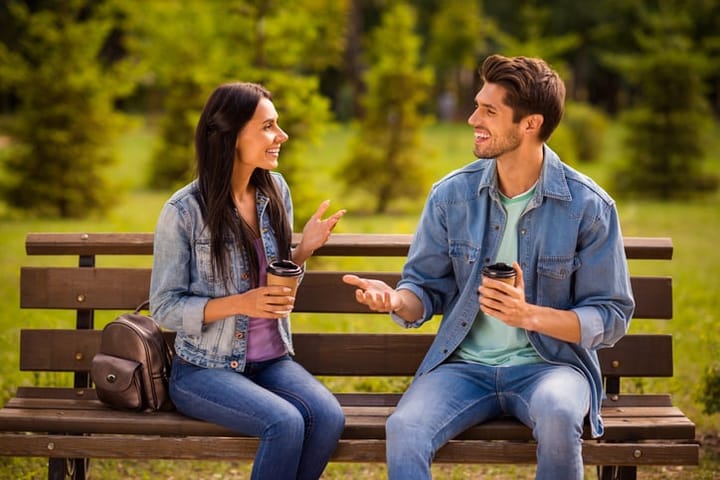 charming guy flirting with woman on bench
