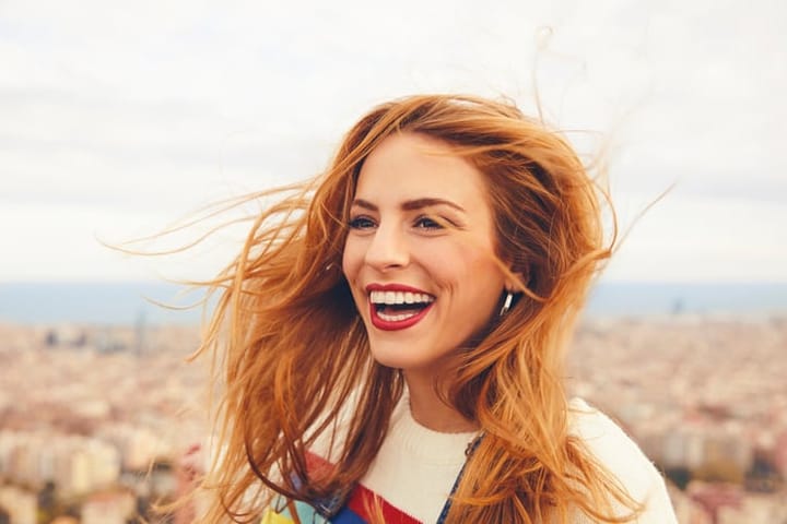 red haired woman smiling in the wind
