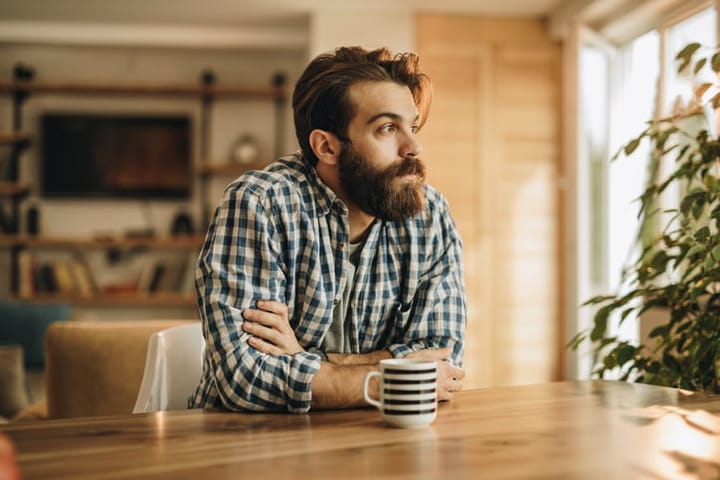 bearded man sitting alone with coffee