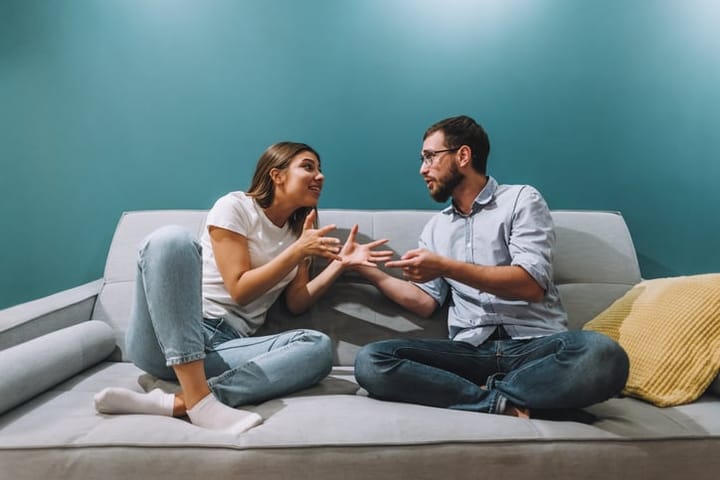 Frustrated young couple sitting on the couch and quarreling with each other at home. High quality photo