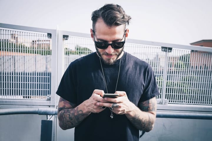 urban man sunglasses texting