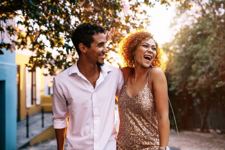 black couple laughing in the street
