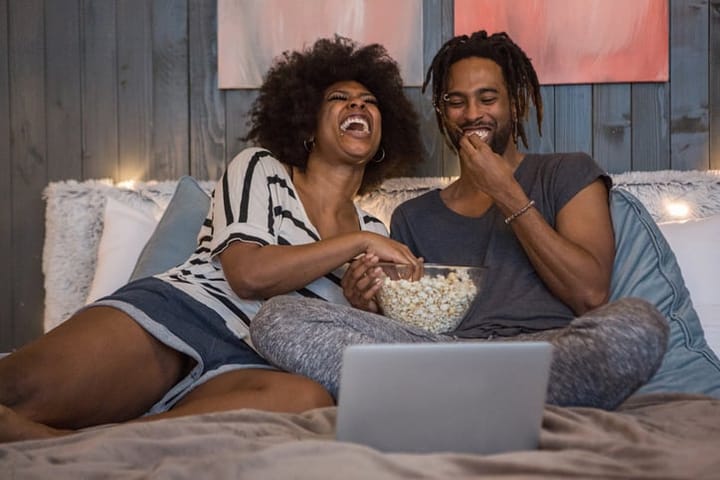 two black people eating popcorn