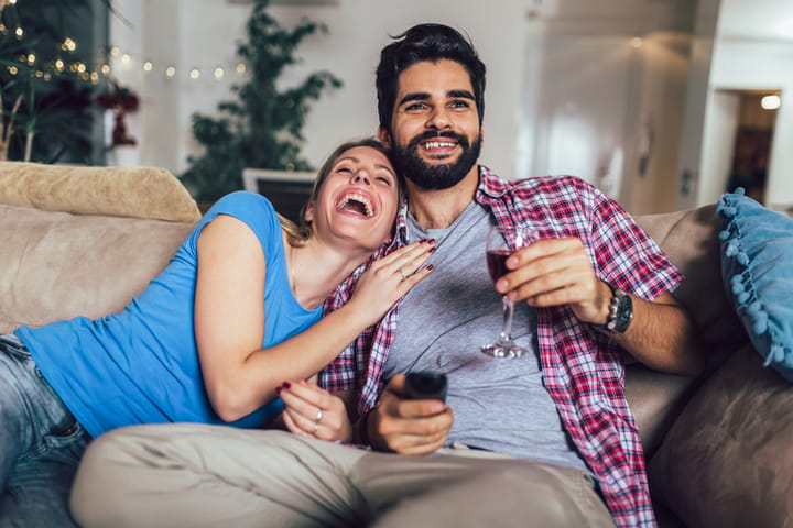 couple laughing at the television