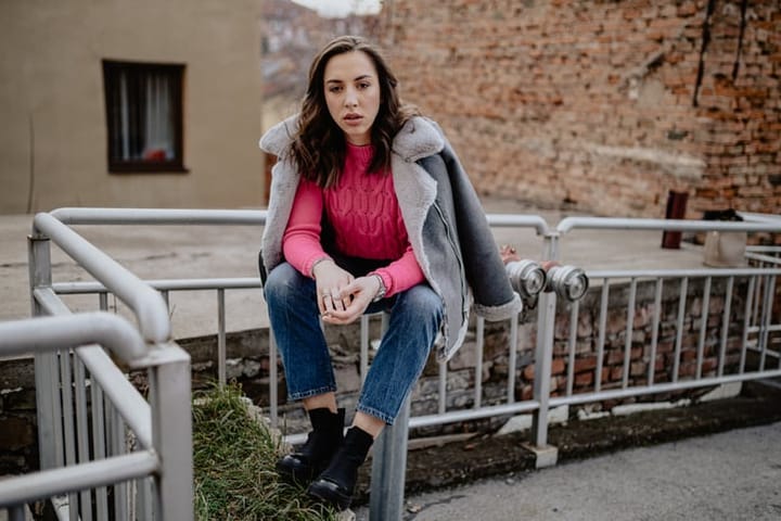 woman sitting railings in a coat